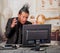 Close up of stressful office punk worker wearing a suit with a crest, working in a computer, in a blurred background