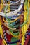 Close up of strings of colorful glass beads hanging infront of a basket and a colorful material. Vertical image