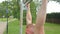 Close up of strong male athlete doing pull-up on horizontal bar outdoors in park