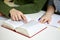 Close up of students hands with book or textbook