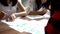 Close up of Students write and lend another student to borrow her pen on table at library