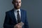 Close-up, studio dramatic portrait of a handsome bearded man, in a business suit, holding a new smartphone in his hand, against a