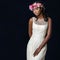 Close up studio portrait of attractive young african bride wearing white wedding gown. Medium shot of girl with colorful flower g