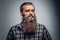 Close up studio portrait of bearded male dressed in a plaid shir