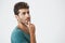 Close up studio portrait of handsome spanish male in blue tshirt, looking up with thoughtful expression, thinking about