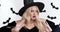 Close up studio portrait of young woman in Halloween witch costume getting amazed and surprised