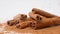 Close up studio shot of food ingredient. A pile of brown dried cinnamon sticks laying on the white background with