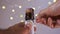 Close up studio shot of man opening champagne with defocused festive lights in the background