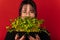 Close up studio shot of a woman covering half of her face with micro greens.