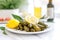 close-up of stuffed vine leaves on white plate, lemon slices on side