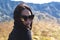 Close-up of a stylish asian woman with sunglasses admiring the view in a mountainous landscape, embodying leisure and travel. At