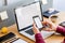 Close up of stylish composition with businessman, mock up laptop screen, cup of coffee, plants and office supplies in modern home