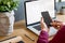 Close up of stylish composition with businessman, mock up laptop screen, cup of coffee, plants and office supplies in modern home