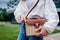 Close-up of stylish female straw handbag. Young woman wearing outfit and accessories outdoors. Summer purse