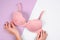 Close-up of stylish pink bra in female hands. Examines woman breasts concept. Top view