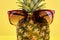 Close up stylish sunglasses on pineapple.