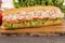 Close up of submarine tuna sandwich on wooden plank