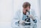 Close up. a successful scientist with a microscope sitting at a laboratory table.