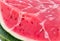 A close-up of a succulent watermelon slice, its juicy, pink flesh glistening in the sun.