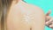 Close up of sunscreen lotion in shape of sun on girls body, sunbathing near pool