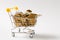 Close up of supermarket grocery push cart for shopping with yellow plastic handle with golden coins falling into it