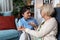 Close up of supportive female caregiver hold hand of mature grandmother visit patient at home, caring woman doctor support old