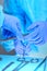 Close-up of of surgeons hands at work in operating theater toned in blue