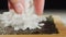 CLOSE UP: A sushi chef\'s hand puts a rice on a nori