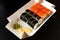 Close up sushi maki rolls and nigiri with shrimp on takeaway recycling eco box. Delivery food concept. Lunchtime on