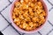 Close-up sweet popcorn in a bowl on white cotton napkin.