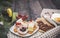 Close-up of sweets on a white plate: coconut biscuit, pastila, meringue, cream roses, Turkish delight, next to a broken chocolate