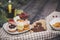 Close-up of sweets on a white plate: coconut biscuit, pastila, meringue, cream roses, Turkish delight, next to a broken chocolate