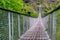 Close-up of a swinging suspension bridge leading to the cave city of Khndzoresk over a gorge in the mountains