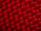 Close-up of synthetic fabric, red fiber. Small gaps between fibers, neat weave,