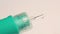 Close-up syringe needle with flowing medicine.