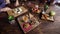 Close up of table served with assorted food setting on wooden platters. Image of different dishes and snacks on the