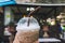 Close up takeaway plastic cup of delicious iced coffee over beautiful blurred coffee shop background. Plastic glass of refreshing