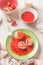 Close up of tasty boiled cottage dumplings stuffed  with fresh strawberries with sweet berries sauce on white kitchen table. Top