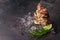 Close-up of tasty fresh oysters with ice cubes and a lime segment on a black background. Delicious tropical mollusk