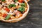 CLOSE-UP Tasty Italian Hot Pizza on dark wooden table with mushrooms, basil, tomato, olives and cheese. Look as Prosciutto,