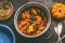 Close up of tasty pumpkin dish in cooking pot on dark rustic kitchen table background, top view. Pumpkin stew.