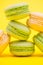 Close up of tasty variation of fresh macaroons on yellow background