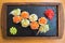 Close up of tasty wooden tray of sushi on a black plate standing on a wooden table in a Japanese restaurant