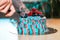 Close up of tattooed man cutting cake with colourful cream