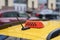 Close-up of taxi sign, symbol on car. Abstract traffic. Urban blurred background