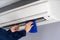 Close up technician service cleaning air conditioner with cloth
