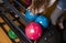 Close-up on teen children hand holding bowling ball against bowling alley - Image. Cheerful Kids are  ready to play - Image.  The