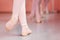 Close-up of teenage ballerina`s feet, practicing ballet moves in a dancing studio