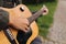 Close-up of teenage boy playing guitar. Male finger on strings. Boy play music. Autumn mood outdoors