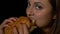 Close-up of a teenage cute girl enjoying a fresh hamburger